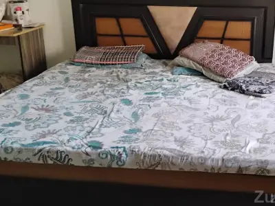 Queen-size wooden bed with a designer headboard