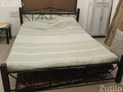 A rot iron double bed with 4 wooden corner legs A rot iron double bed with 4 wooden corner legs